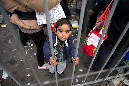 A boy looks on as he waits to board a bus in Sentilj, northeastern Slovenia to continue his journey and cross the Slovenia-Austria border. 
